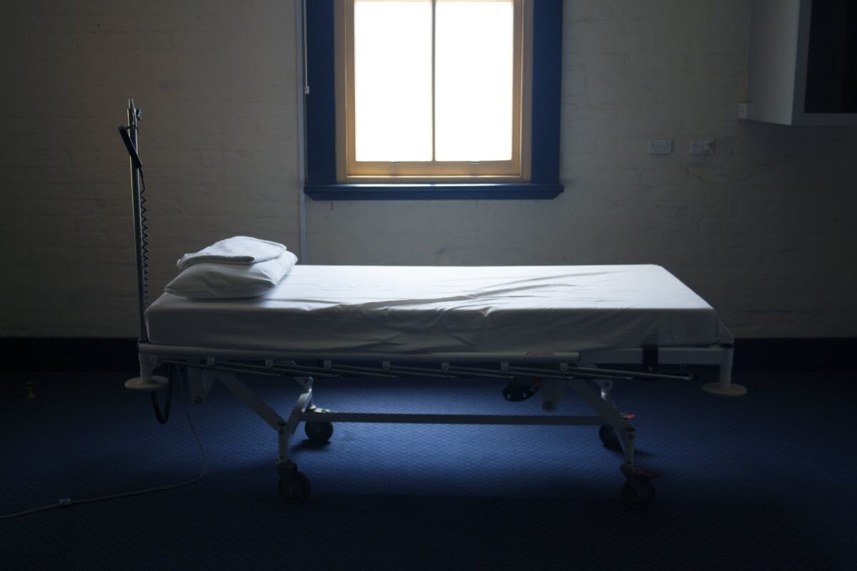 empty hospital cot in bare room