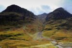 Mountains covered in greenish-orange moss and flora