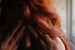 woman's face in hands and in red hair