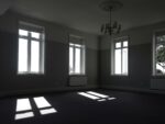 empty room with four windows making shadows on the floor