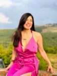 Jennifer Pastiloff in magenta dress with hills and blue sky in back