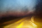 road with misty sky at dusk and flashes of light to emulate motion of cars speeding
