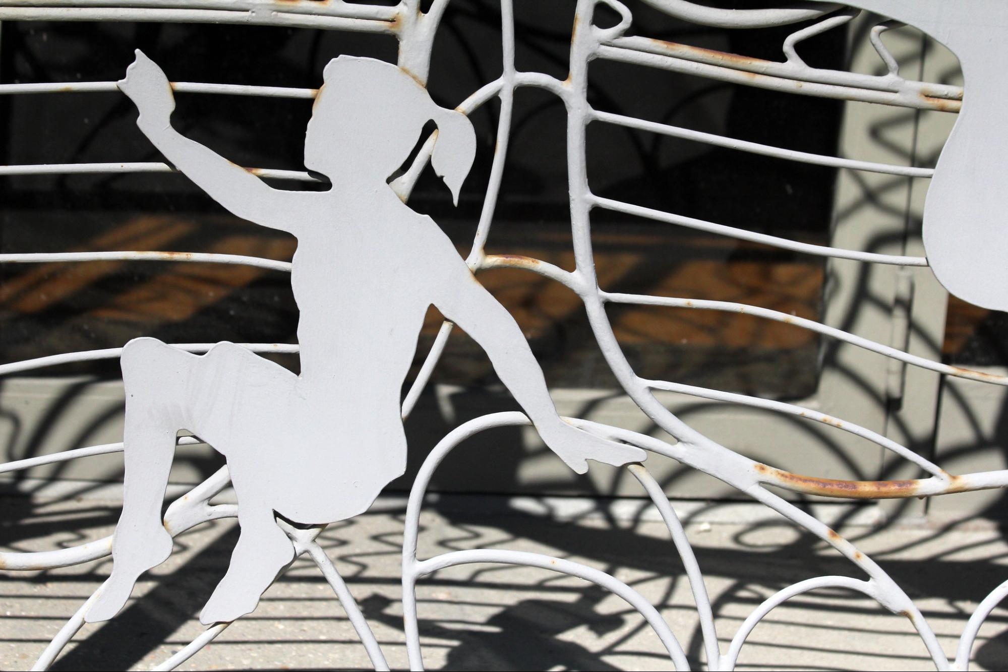 wire bench with cut out of a girl in ponytail