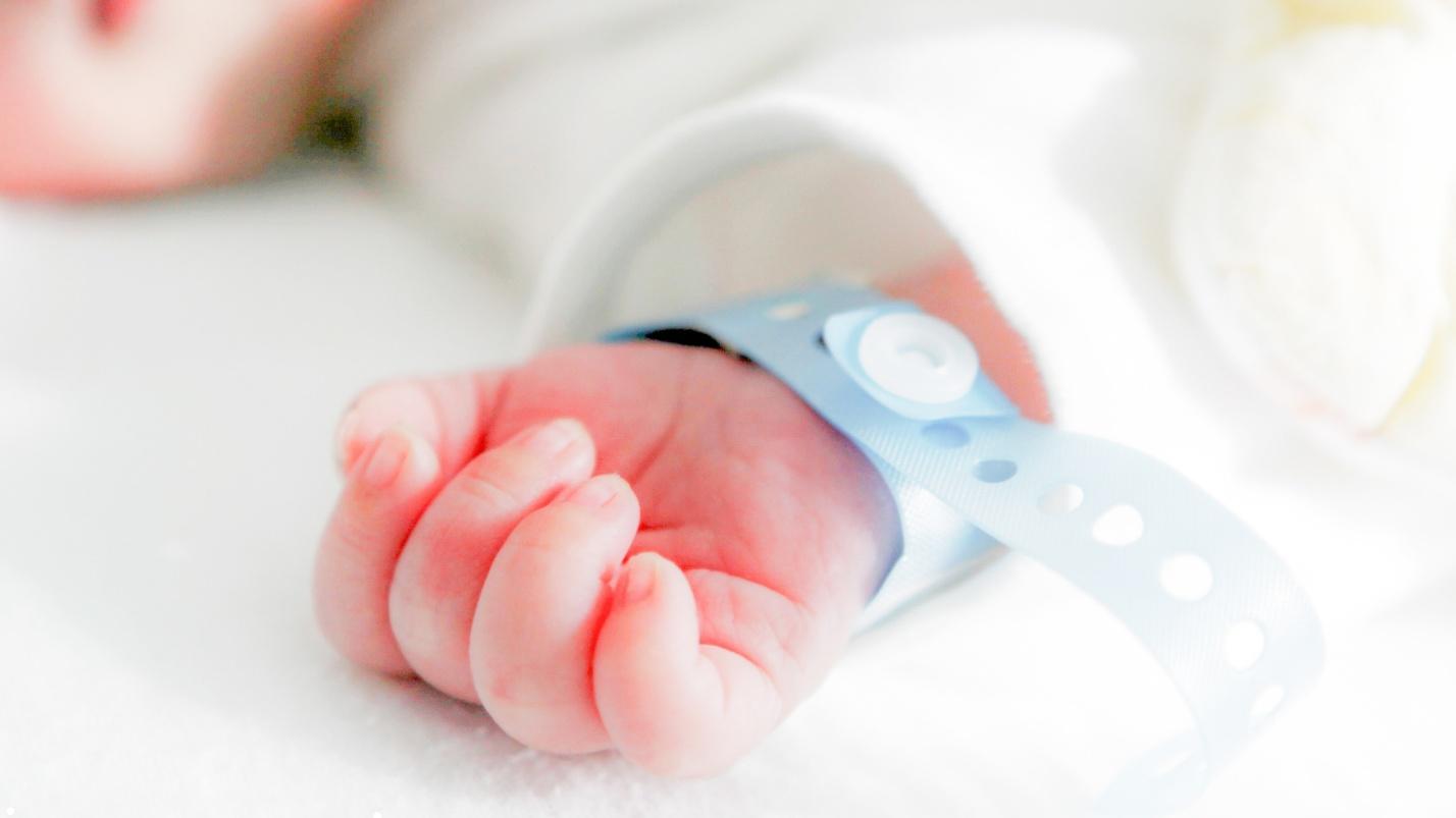 newborn hand with hospital bracelet