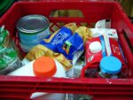crate of groceries, including milk, juice, and veggie cans