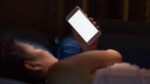 woman in bed with bright phone screen lit up