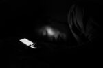 iphone screen glowing in an otherwise dark room